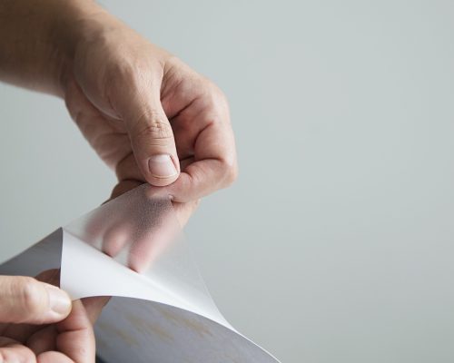 Man installing sticker film to mirror window house interior decoration